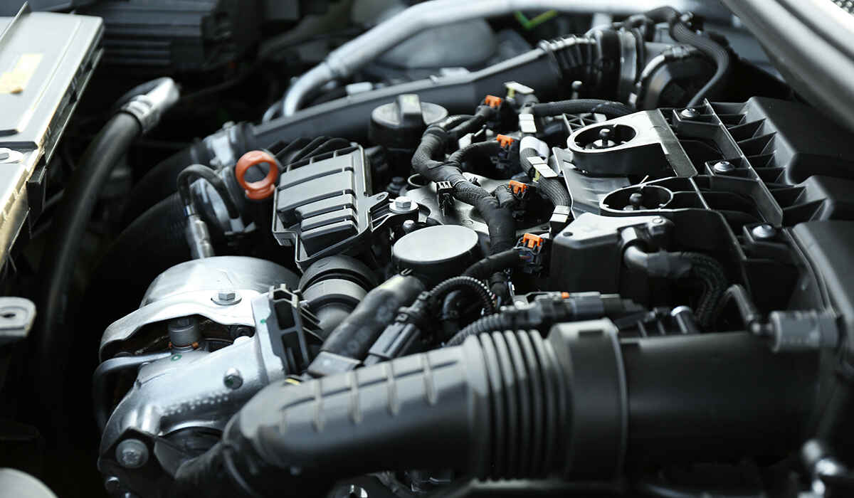Close-up of a modern car engine bay highlighting the black plastic air intake ducting and manifold components.