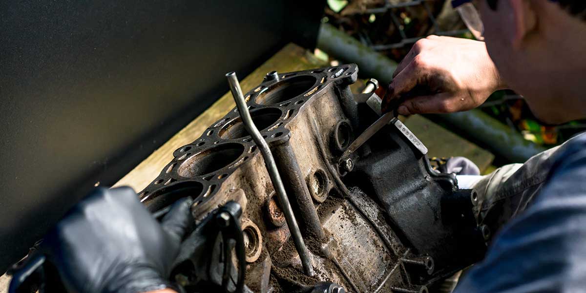 A mechanic carefully inspects and services an engine block component to ensure optimal airflow and maximize overall engine efficiency.